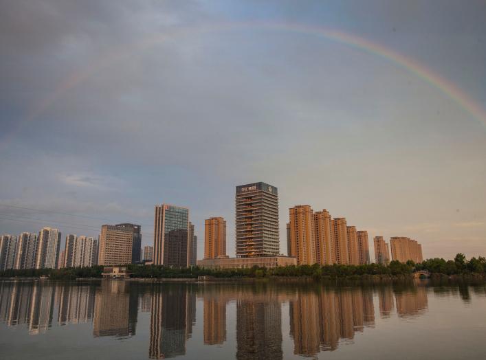 A rainbow appears over buildings reflected in water early morning in Shaoxing, China June 17, 2017. Picture taken June 17, 2017. REUTERS/Stringer 
