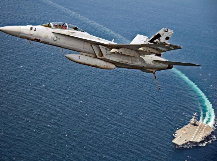 An F/A-18F Super Hornet jet flies over the USS Gerald R. Ford as the U.S. Navy aircraft carrier tests its EMALS magnetic launching system, which replaces the steam catapult, and new AAG arrested landing system in the Atlantic Ocean July 28, 2017. Picture 