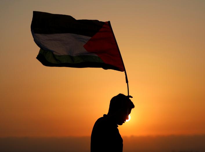 A demonstrator holds a Palestinian flag during a protest against Jewish settlements in the village of Ras Karkar, near Ramallah in the occupied West Bank August 30, 2018. REUTERS/Mohamad Torokma
