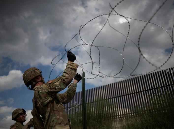 The border wall is seen in the background as U.S. Army soldiers install concertina wire along the United States - Mexico border in Hidalgo, Texas, U.S., November 8, 2018. Picture taken on November 8, 2018. REUTERS/Adrees Latif