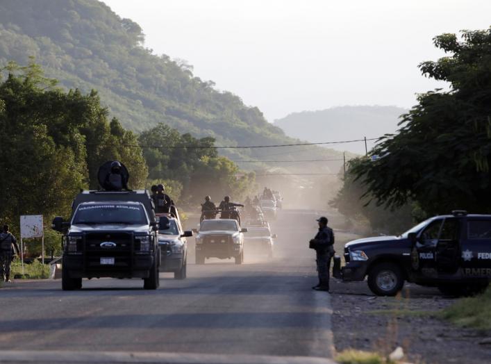 Security forces patrol along a road after police officers were killed during an ambush by suspected cartel hitmen in El Aguaje, in Michoacan state, Mexico October 14, 2019. REUTERS/Alan Ortega