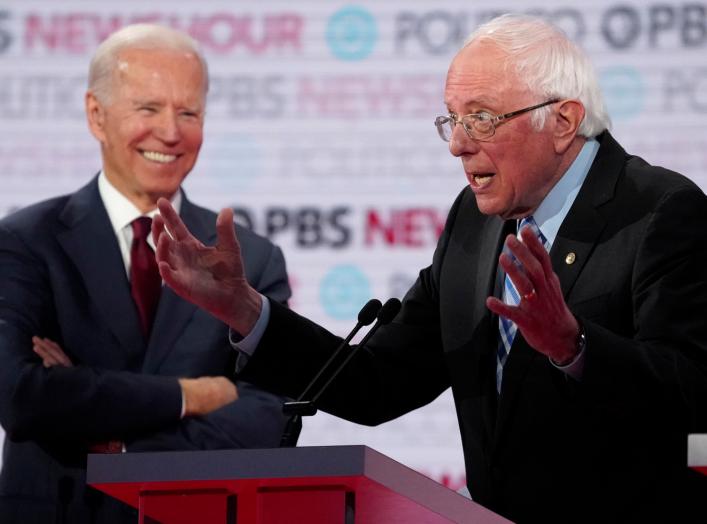 Former Vice President Joe Biden laughs as Senator Bernie Sanders speaks at the 2020 Democratic campaign debate at Loyola Marymount University in Los Angeles, California, U.S., December 19, 2019. REUTERS/Mike Blake