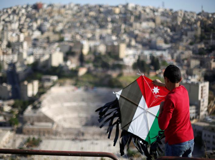 A boy flies his kite decorated with the Jordanian national flag during an event celebrating spring at the Citadel in Amman, Jordan, April 15, 2016. REUTERS/Muhammad Hamed