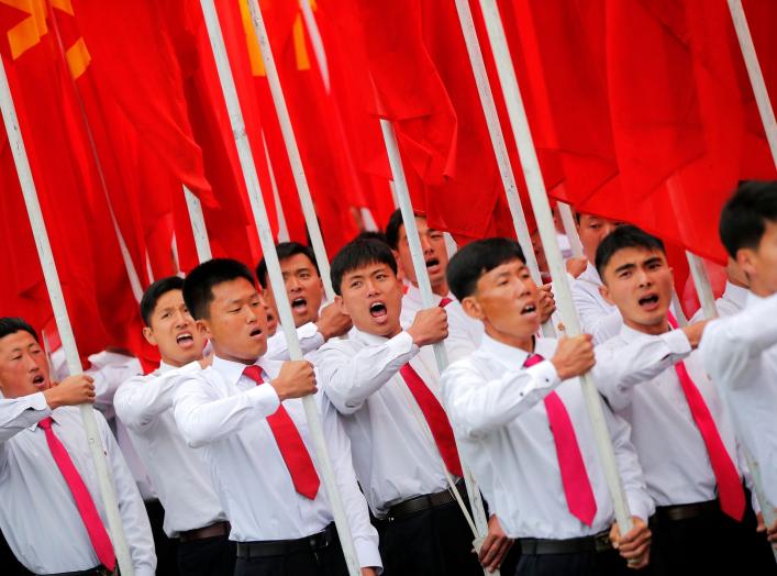 Students carrying party flags shout slogans as they march past North Korean leader Kim Jong Un during a mass rally and parade in the capital's main ceremonial square, a day after the ruling party wrapped up its first congress in 36 years by elevating him 