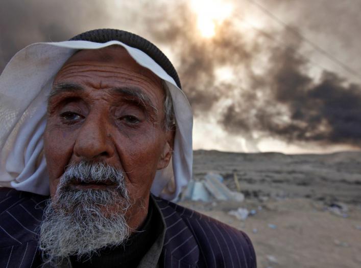 A man returns to his village after it was liberated from Islamic State militants, south of Mosul in Qayyara, Iraq, October 22, 2016. The fumes in the background are from oil wells that were set ablaze by Islamic State militants. REUTERS/Alaa Al-Marjani TP