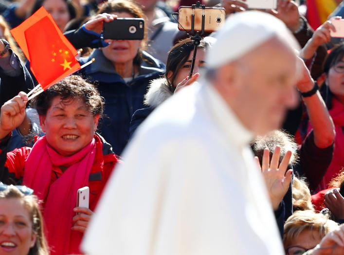 A Chinese pilgrim waves a flag, as Pope Francis arrives to lead his Wednesday general audience, in Saint Peter's Square, at the Vatican March 15, 2017. REUTERS/Tony Gentile