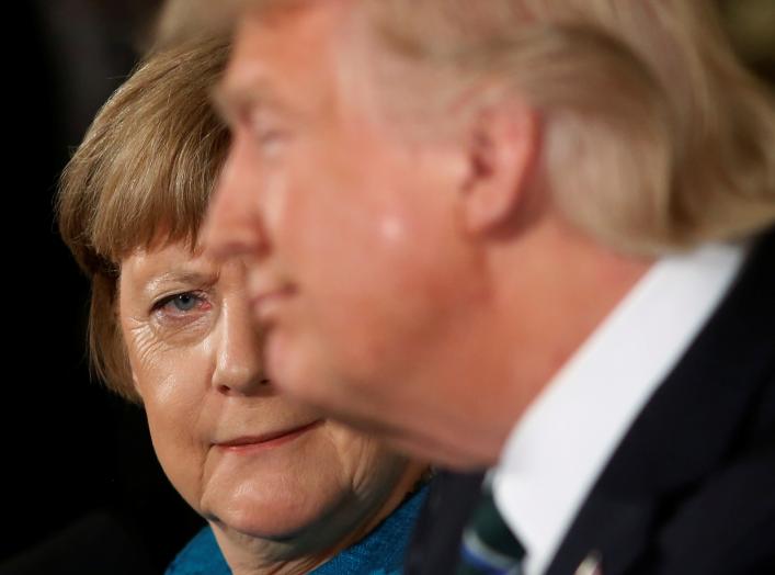 Germany's Chancellor Angela Merkel (L) gives U.S. President Donald Trump a look after he suggested they might have something in common, as he answered a question about his accusation that he had been wiretapped by former President Barack Obama, during the