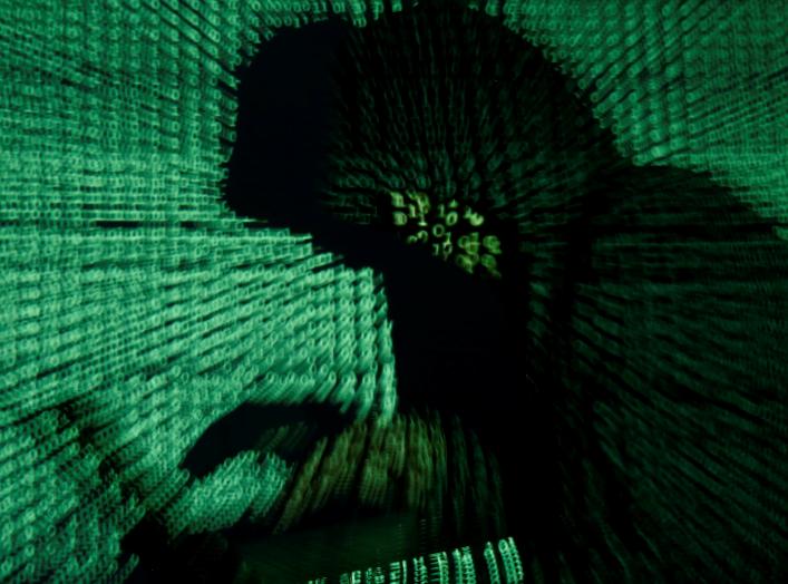 A man holds a laptop computer as cyber code is projected on him in this illustration picture taken on May 13, 2017. REUTERS/Kacper Pempel