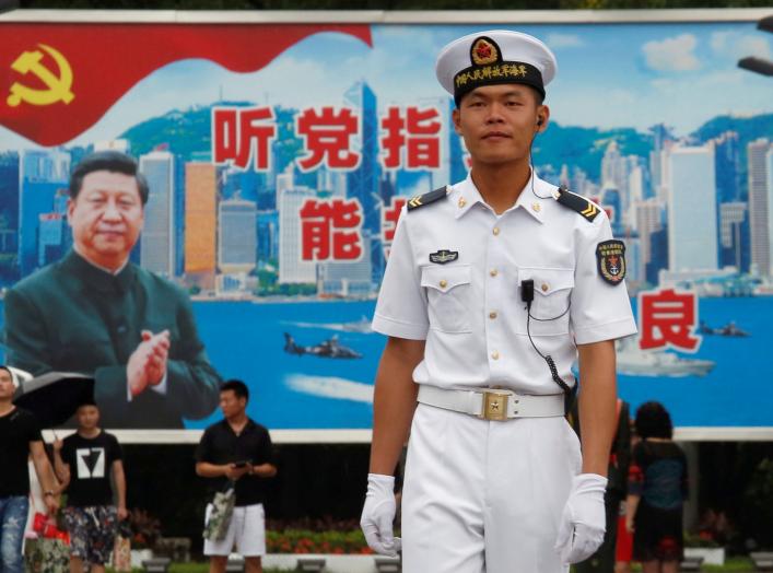 A People's Liberation Army Navy soldier stands in front of a backdrop featuring Chinese President Xi Jinping at a naval base in Hong Kong, China July 8, 2017. REUTERS/Bobby Yip