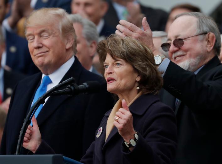 U.S. President Donald Trump stands with with Alaska's Sen. Lisa Murkowski (R-AK), and Rep Don Young (R-AK) as he celebrates with Congressional Republicans after the U.S. Congress passed sweeping tax overhaul legislation on the South Lawn