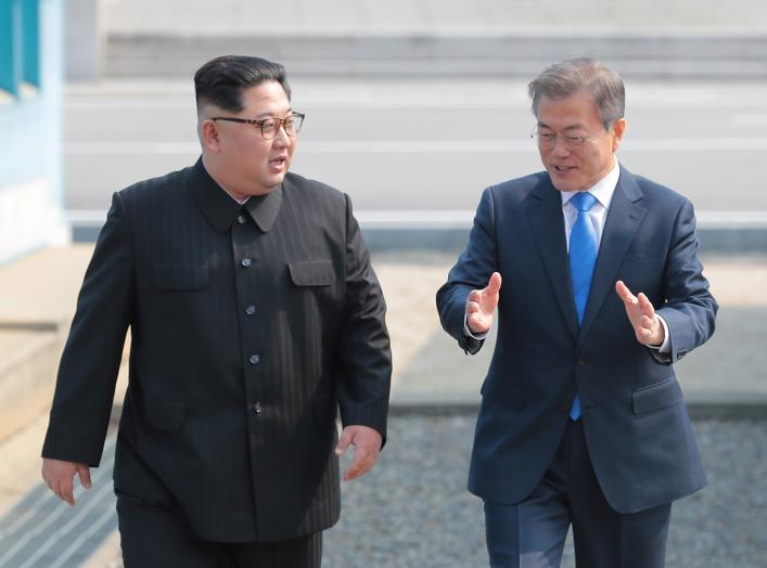 South Korean President Moon Jae-in walks with North Korean leader Kim Jong Un during their meeting at the truce village of Panmunjom inside the demilitarized zone separating the two Koreas, South Korea, April 27, 2018. Korea Summit Press Pool/Pool via Reu