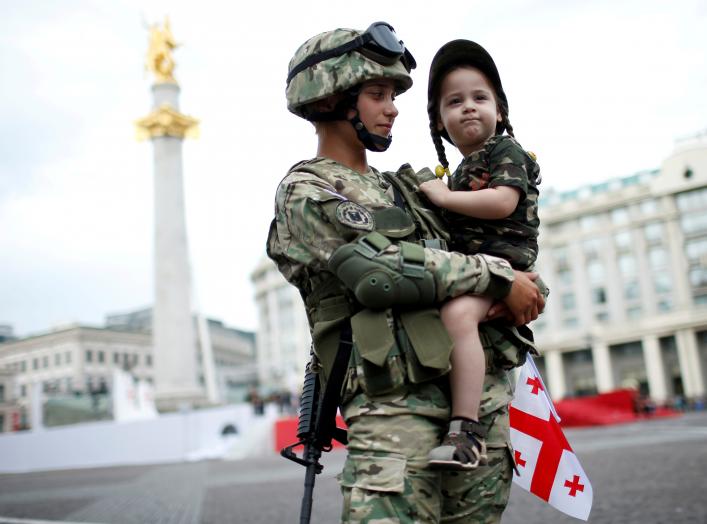 Servicewoman, Tamar Kurkumuli, 25, holds her 3-year-old daughter Nino, before the oath-taking ceremony as Georgia marks the 100th anniversary of its independence in Tbilisi, Georgia, May 26, 2018. REUTERS/David Mdzinarishvili 