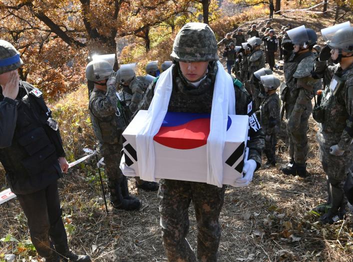 A South Korean soldier carries a casket containing a piece of bone believed to be the remains of an unidentified South Korean soldier killed in the Korean War in the Demilitarized Zone (DMZ) dividing the two Koreas in Cheorwon, South Korea October 25, 201