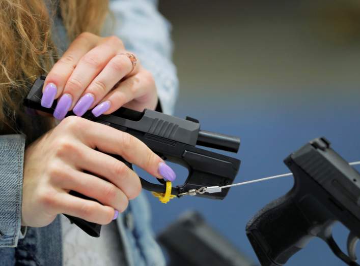 A woman handles a gun inside of the Sig Sauer booth during the National Rifle Association (NRA) annual meeting in Indianapolis, Indiana, U.S., April 28, 2019. REUTERS/Lucas Jackson