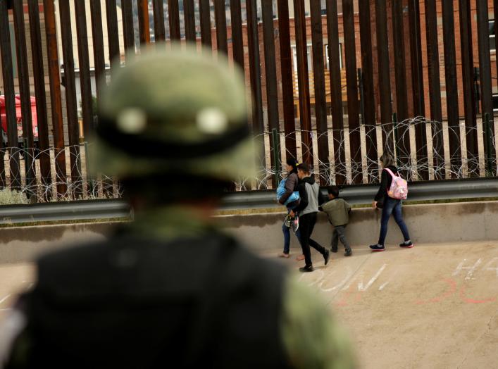 A National Guard soldier observes migrants after crossing illegally into El Paso, Texas, U.S. to turn themselves in to U.S. Border Patrol agents to ask for asylum, as seen from Ciudad Juarez, Mexico September 15, 2019. REUTERS/Jose Luis Gonzalez