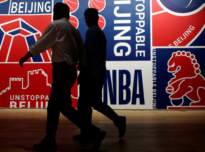 Men walk past a poster at an NBA exhibition in Beijing, China October 8, 2019. REUTERS/Jason Lee/File Photo