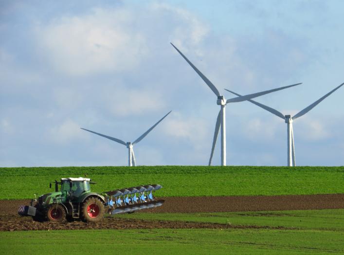 A French farmer drives a tractor as he ploughs a field in front of power-generating windmill turbines on a wind park in Havrincourt, France, November 10, 2019. Picture taken November 10, 2019. REUTERS/Pascal Rossignol