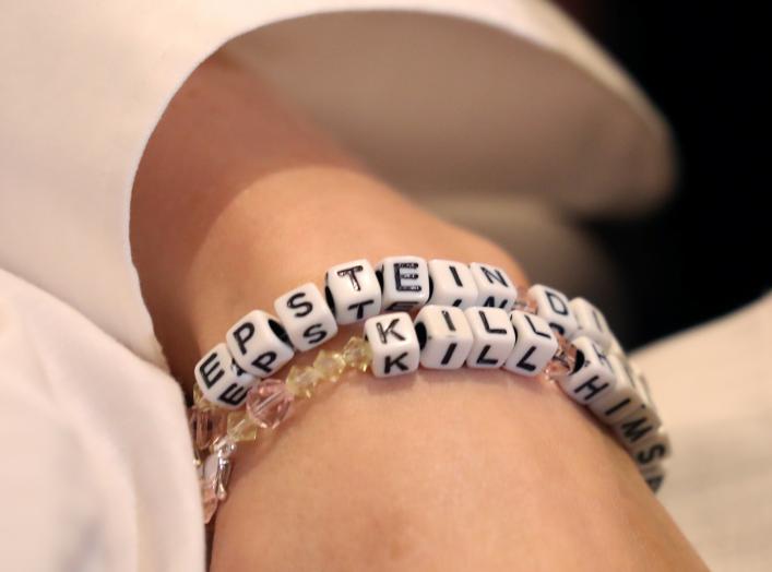 "Jane Doe 15," a 31-year-old unidentified woman, who accuses the late financier Jeffrey Epstein of sexually abusing her when she was a child, wears a bracelet that reads "Epstein didn't kill himself" as she speaks at a news conference