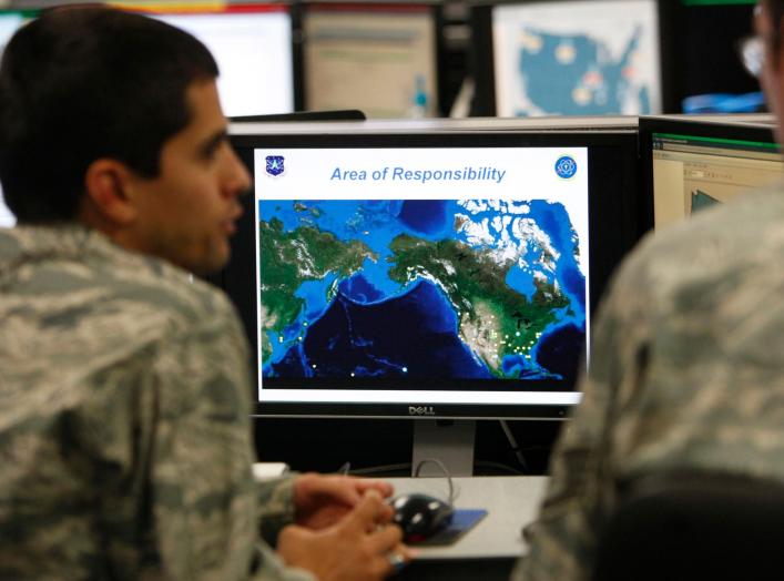 2Lt William Liggett (L) talks with a colleague as a map is displayed on one of the screens at the Air Force Space Command Network Operations & Security Center at Peterson Air Force Base in Colorado Springs, Colorado July 20, 2010. U.S. national security p