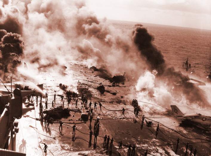View of the U.S. Navy aircraft carrier USS Enterprise (CVAN-65) underway in the Pacific Ocean showing the crew fighting a fire on the flight deck that occurred as the carrier was conducting air operations near Hawaii.