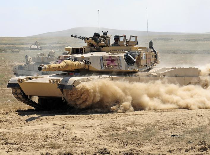 A U.S. Army M1A2 Abrams main battle tank assigned to the Minnesota National Guard races through a breach in a barbed wire obstacle during the 116th eXportable Combat Training Exercise at the Orchard Combat Training Center, Idaho, Aug. 21, 2014