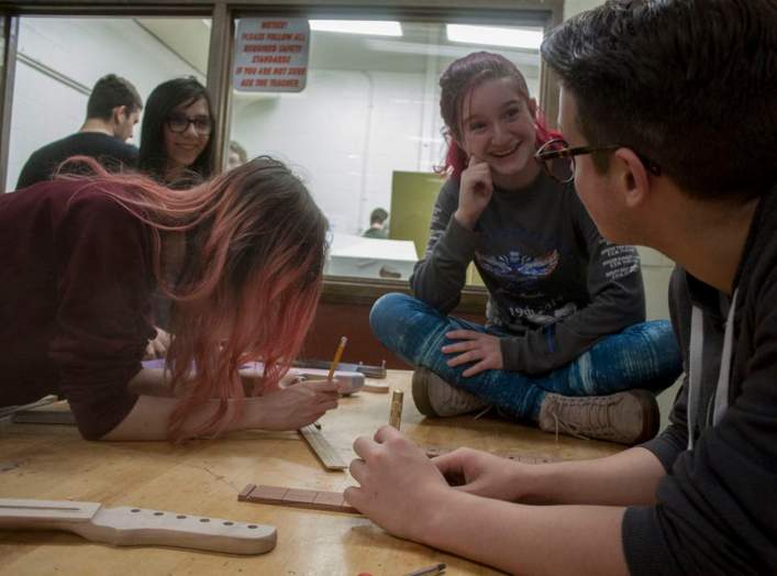 Students work together when they build guitars in class, reinforcing what they learn.  James Cordero, CC BY-SA