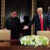 FILE PHOTO: U.S. President Donald Trump and North Korea's leader Kim Jong Un (L) arrive to sign a document to acknowledge the progress of the talks and pledge to keep momentum going, after their summit at the Capella Hotel on Sentosa island in Singapore, 