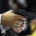 A man holds a Sig Sauer pistol during the Defence Security Equipment International (DSEI) arms fair at ExCel in London September 10, 2013. REUTERS/Stefan Wermuth