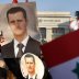 Supporters of Syrian President Bashar al-Assad carry Syrian flags and portraits in front of the United Nations European headquarters in Geneva January 31, 2014. REUTERS/Denis Balibouse