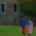 People wear the American flag as students and protesters gather at the "Free Speech Zone" located at the University of Colorado's Business Field, while candidates gather across the street for a forum held by CNBC, before the U.S. Republican presidential c