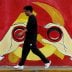 A man walks next to a mural showing an image of the Chinese Communist Party's emblem along a street in Shanghai, China September 25, 2019. REUTERS/Aly Song