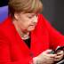 FILE PHOTO: German Chancellor Angela Merkel checks her phone at the lower house of parliament (Bundestag), ahead of a Brussels summit for Brexit delay discussions, in Berlin, Germany March 21, 2019. REUTERS/Hannibal Hanschke/File Photo