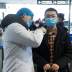 A medical official takes the body temperature of a man at the departure hall of the airport in Changsha, Hunan Province, as the country is hit by an outbreak of a new coronavirus, China, January 27, 2020. REUTERS/Thomas Peter