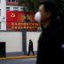People wearing masks walk past a portrait of Chinese President Xi Jinping on a street as the country is hit by an outbreak of the novel coronavirus in Shanghai, China February 10, 2020. REUTERS/Aly Song