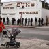 A pedestrian pushes a stroller as people wait in line outside to buy supplies at the Martin B. Retting, Inc. gun store amid fears of the global growth of coronavirus cases, in Culver City, California, U.S. March 15, 2020. REUTERS/Patrick T. Fallon