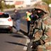 A soldier stands guard as he is joined by police officers to check vehicles as a 21-day lockdown aimed at limiting the spread of coronavirus disease (COVID-19) takes effect in Cape Town, South Africa, March 27,2020.REUTERS/Mike Hutchings