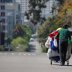 A homeless man pushes a cart full of his belongings along an empty street during the outbreak of the coronavirus disease (COVID-19) in San Diego, California, U.S., April 1, 2020. REUTERS/Mike Blake