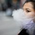 A woman exhales after vaping in Times Square, during the coronavirus disease (COVID-19) outbreak, in New York City, U.S., March 31, 2020. REUTERS/Brendan McDermid