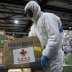 A worker carries a box while unloading a shipment of medical and protective gear sent from China to help the fight against coronavirus disease (COVID-19) outbreak at Almaty International Airport, Kazakhstan April 2, 2020. REUTERS/Pavel Mikheyev