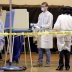 A poll worker wearing a mask to help slow the spread of coronavirus disease (COVID-19) sprays down a voting booth after use during the presidential primary election at Riverside High School in Milwaukee, Wisconsin, U.S. April 7, 2020. Mike De Sisti/Milwau