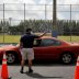 A worker controls the traffic as people in cars wait in line to pick up receiving an unemployment forms, as the outbreak of coronavirus disease (COVID-19) continues, in Hialeah, Florida, U.S., April 8, 2020. REUTERS/Marco Bello