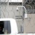 A prison employee drives past a surveillance camera on the grounds of the Otay Mesa Detention Center, a ICE (Immigrations & Customs Enforcement) federal detention center privately owned and operated by prison contractor CoreCivic, amid the coronavirus dis