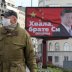 A man wearing a protective mask passes by a billboard depicting Chinese President Xi Jinping as the spread of the coronavirus disease (COVID-19) continues in Belgrade, Serbia, April 1, 2020. The text on the billboard reads "Thanks, brother Xi". Picture ta