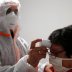 A French doctor wearing a protective suit checks the temperature of a woman in a testing site for the coronavirus disease (COVID-19) in Gouzeaucourt, France, April 28, 2020. REUTERS/Pascal Rossignol