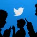 People holding mobile phones are silhouetted against a backdrop projected with the Twitter logo in this illustration picture taken in Warsaw September 27, 2013. REUTERS/Kacper Pempel/Illustration