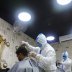 Barbers wearing protective suits and face masks provide hair cut service to the customers inside a salon amid the coronavirus disease (COVID-19) outbreak, in Dhaka, Bangladesh June 16, 2020. REUTERS/Mohammad Ponir Hossain