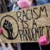 A woman wearing a protective face mask holds a sign during the Black Lives Matter protest, following the death of George Floyd who died in police custody in Minneapolis, in Birmingham, Britain, June 19, 2020. REUTERS/Carl Recine