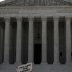 A demonstrator holds a sign reading "follow the money" in anticipation of a U.S. Supreme Court ruling on U.S. President Donald Trump's bid to block his financial records from being obtained by third parties, outside the court in Washington, U.S., July 9, 