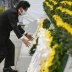 Japan's Prime Minister Shinzo Abe wearing a protective face mask, offers a wreath to the cenotaph for the victims of the 1945 atomic bombing, at Peace Memorial Park in Hiroshima, western Japan, August 6, 2020, on the 75th anniversary of the atomic bombing