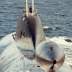 An aerial stern-on view of the Russian Northern Fleet AKULA class nuclear-powered attack submarine underway on the surface.